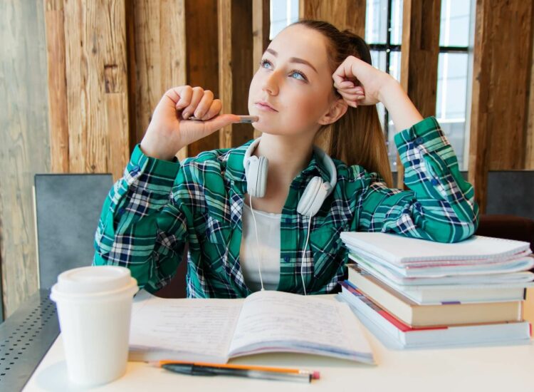 junge Frau vor Büchern beim Lernen